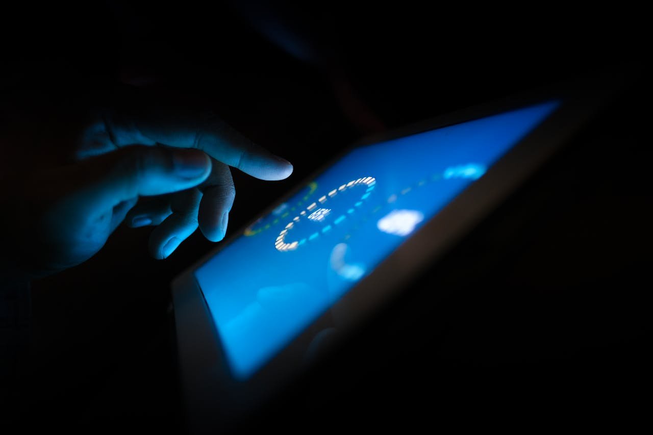 hero-img-01 Close-up of a hand interacting with a glowing touchscreen in a dark setting, highlighting technology use.