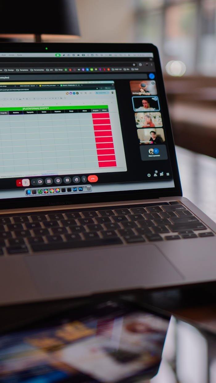 contact-img Laptop displaying a remote video meeting in a modern office setting.