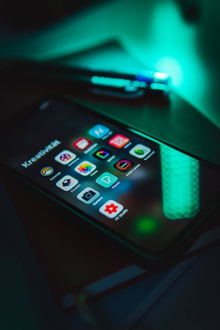 why-choose-us Smartphone displaying colorful app icons in low light, emphasizing technology and connectivity.